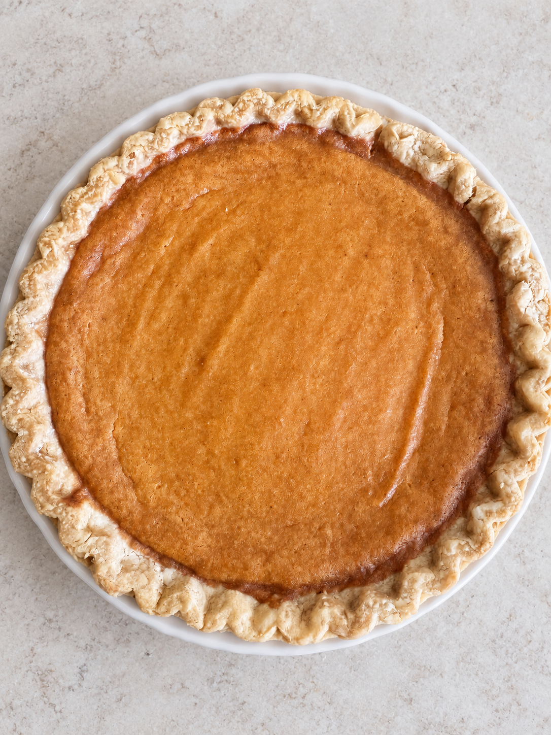 Freshly baked sweet potato pie in a white ceramic pie dish